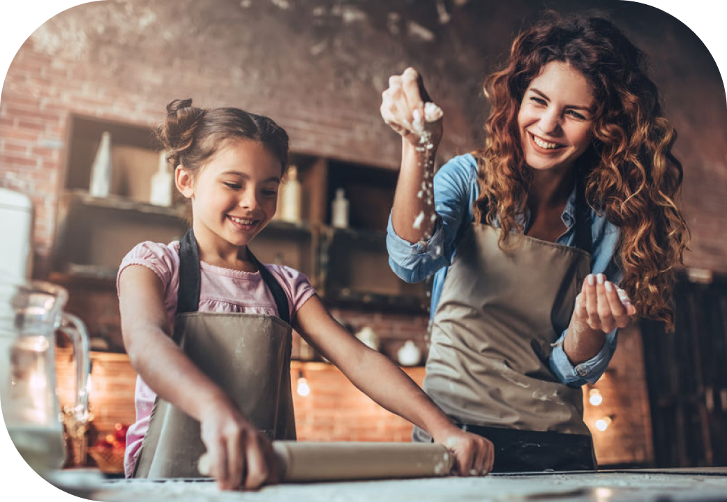 Mother and daughter having fun together while cooking in kitchen
