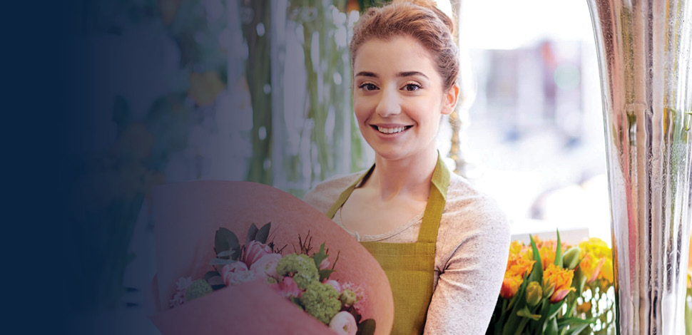 Female florist working in shop preparing a bouquet
