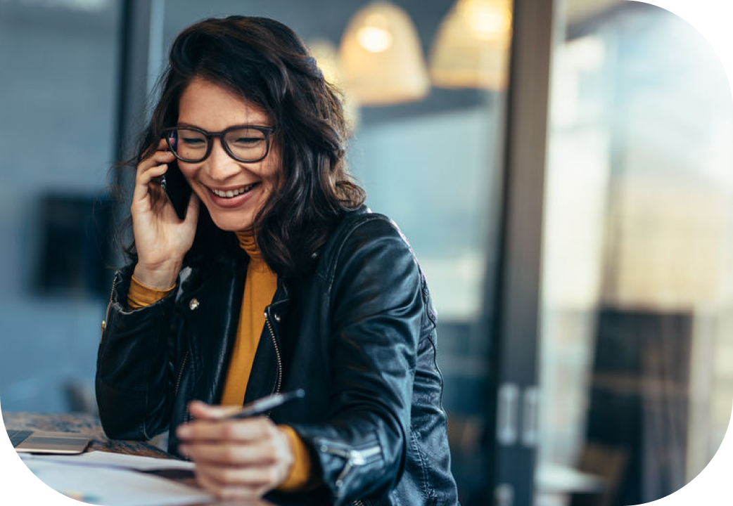 Businesswoman sitting at office on a table talking over mobile phone