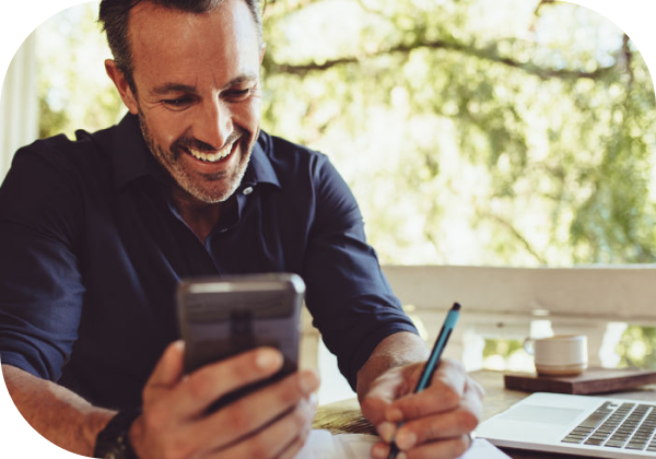 Business man reviewing paperwork while looking at phone