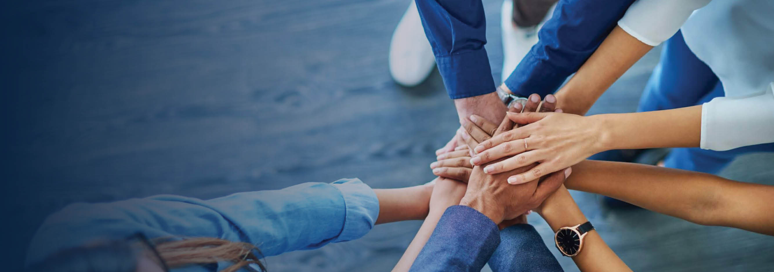 Hands of many individuals together in a circle.