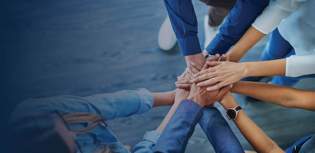 Hands of many individuals together in a circle.