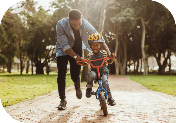 Father teaching his son to ride a bike.