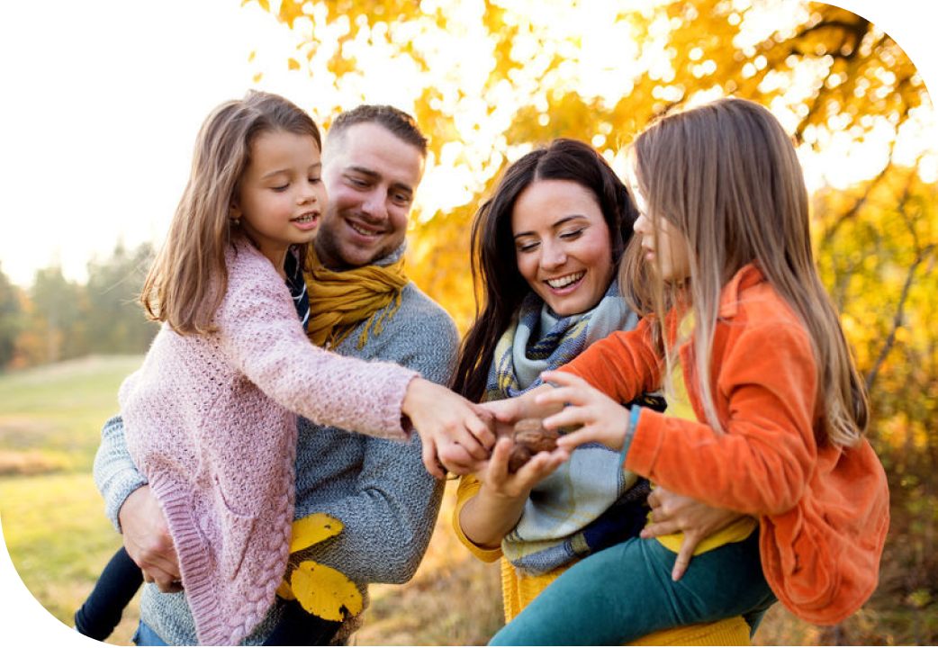 Beautiful young family with two small children in autumn forest