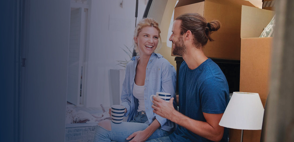 Couple taking a break from unpacking boxes in new home