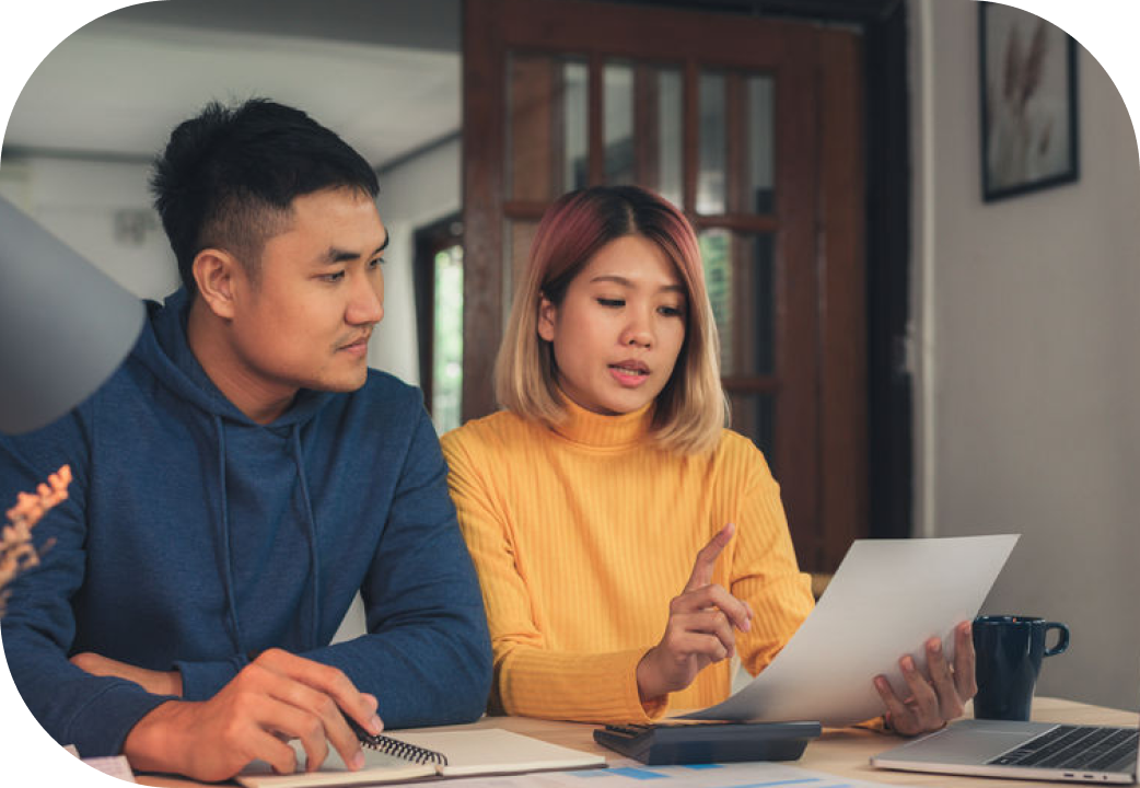 Young couple managing finances, using laptop and calculator at home