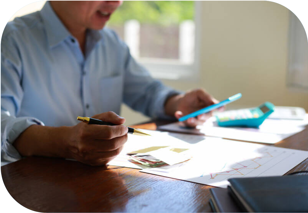 Close up of man reviewing bills while looking at mobile phone