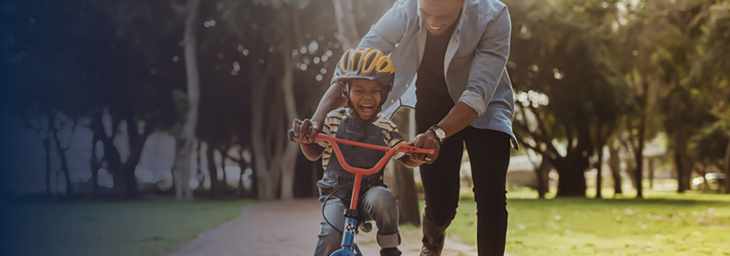 Father teaching his son cycling at park