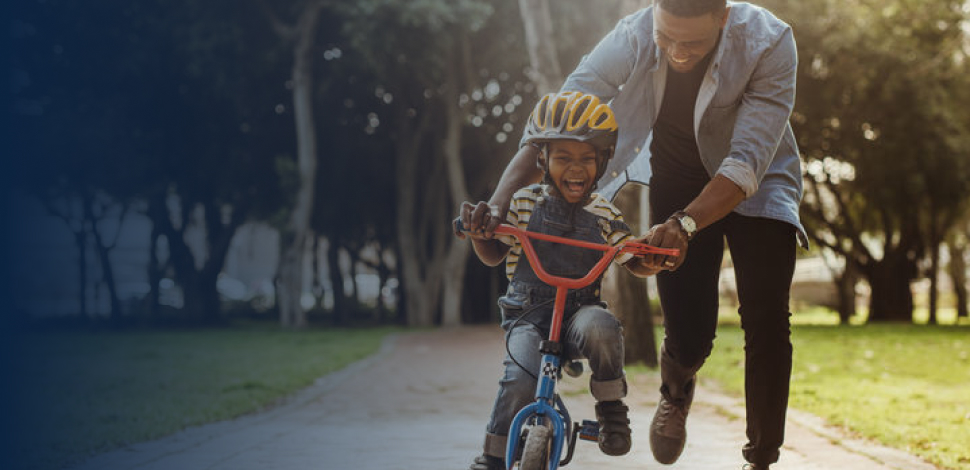 Father teaching his son cycling at park