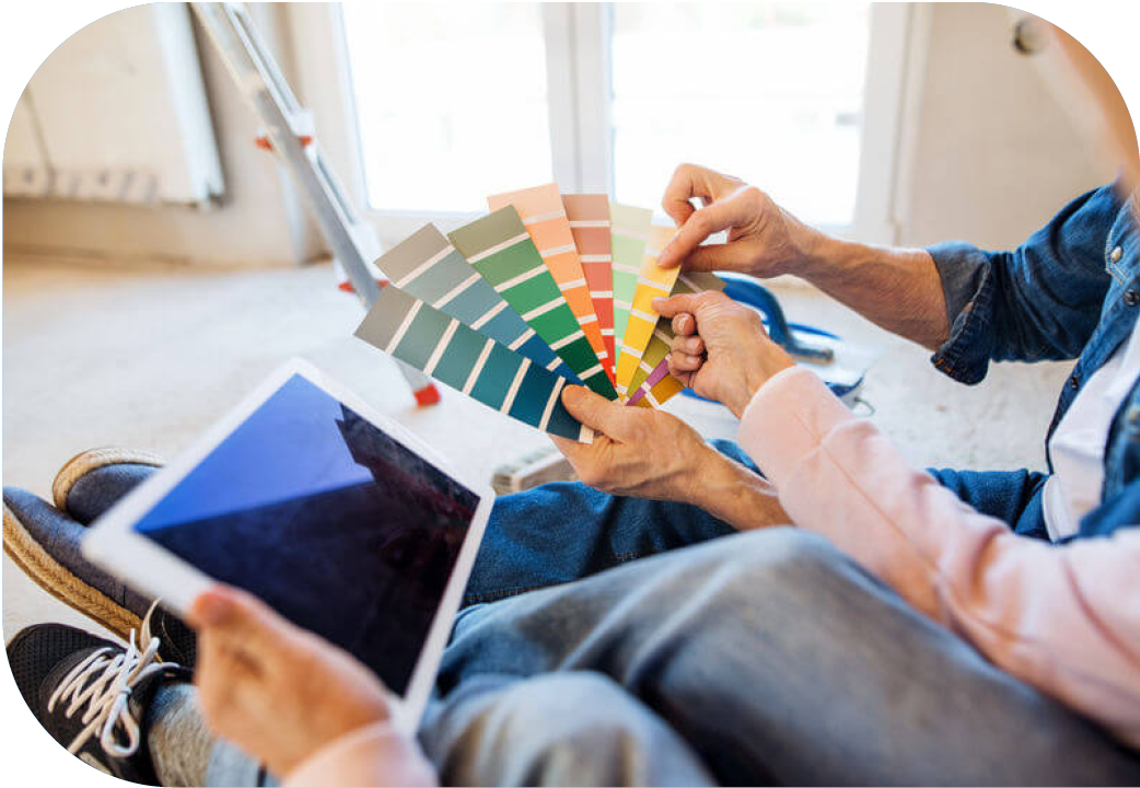 Close up of couple looking at paint chips and tablet.