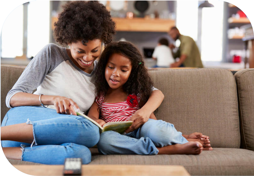 Mother and young daughter reading a book together