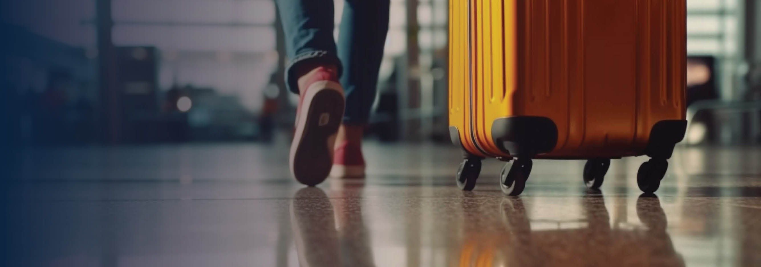 Feet of someone walking through airport with a suitcase