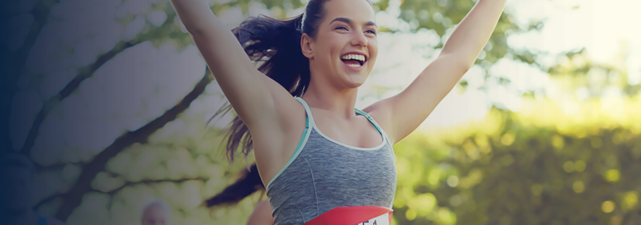 Woman finishing a marathon race, hands raised in celebration