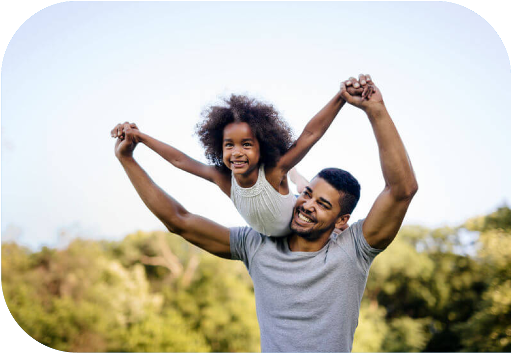 Father holding daughter up over his shoulder, both with outstretched arms.