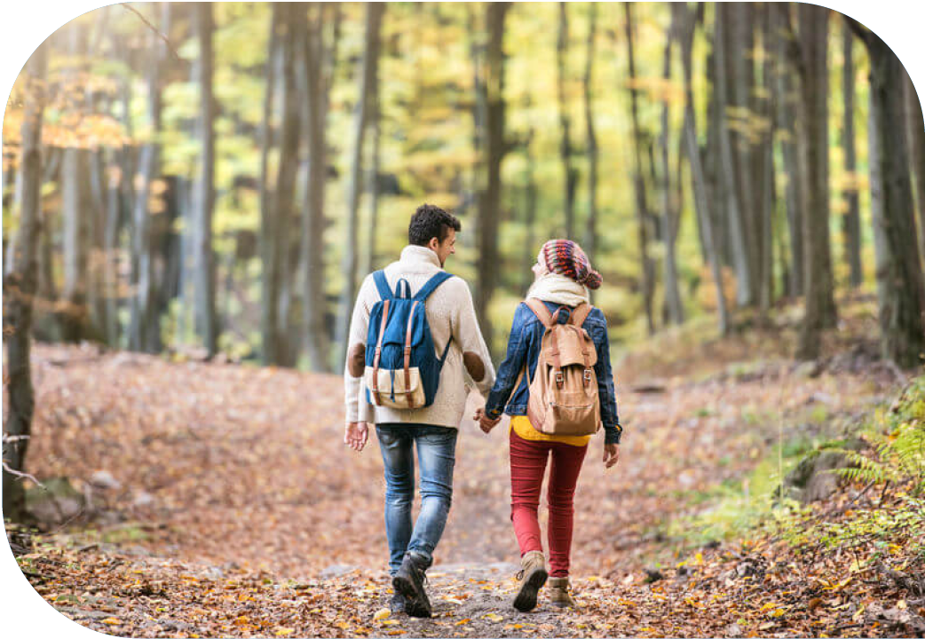 Couple hiking through forest in fall.