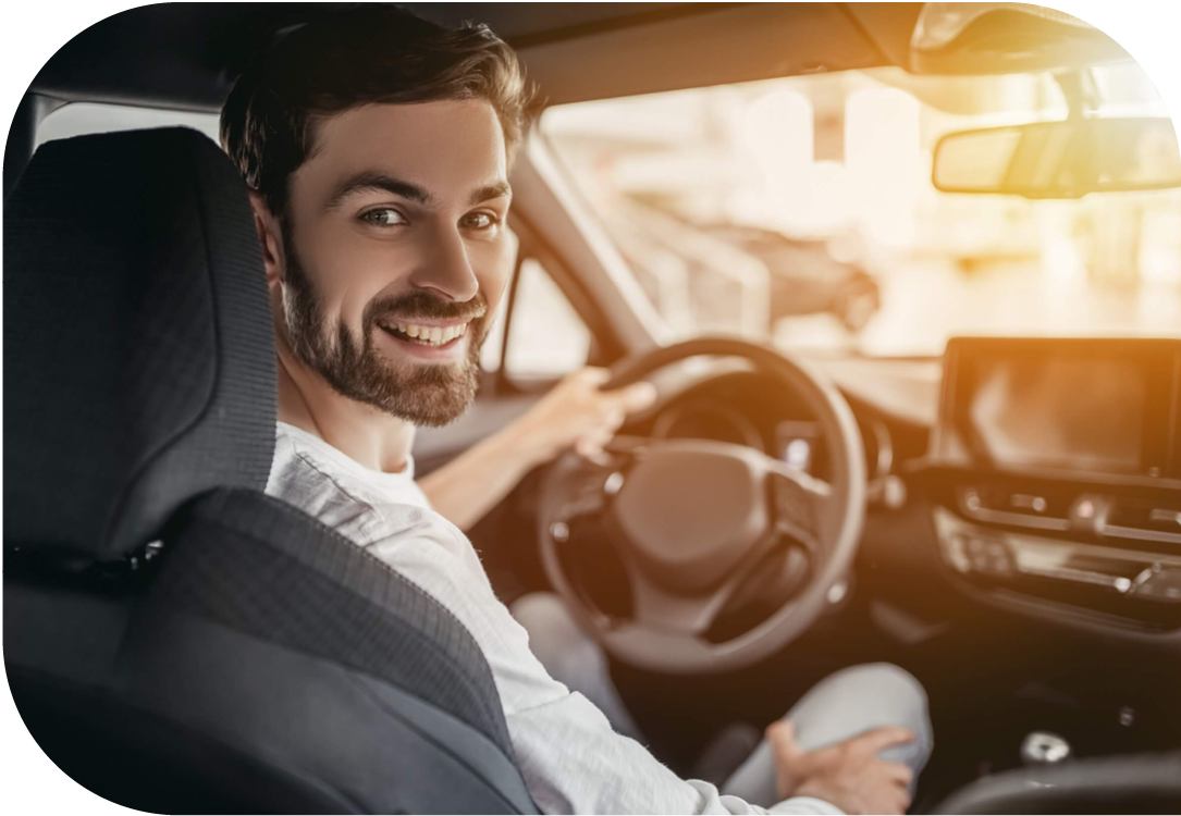 Young woman in new car looking into rear view mirror