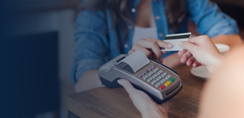 Smiling woman paying for coffee by credit card