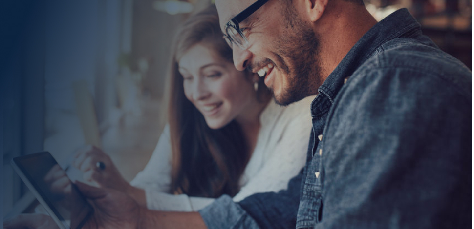 Happy young couple using a digital tablet together at a coffee shop